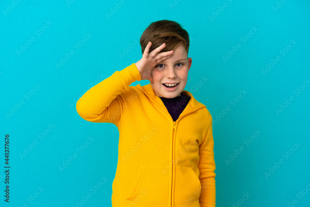 Little redhead boy isolated on blue background has realized something and intending the solution Little redhead boy isolated on blue background has realized something and intending the solution