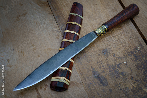 Canvastavla knife custom or Enep in the natural wood scabbard on old table background handma