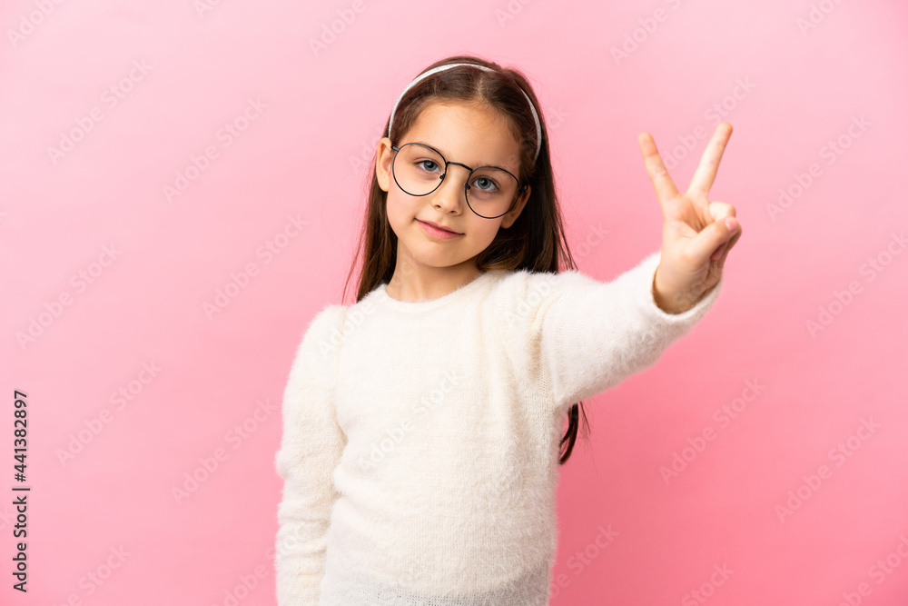Little caucasian girl isolated on pink background smiling and showing victory sign Little caucasian girl isolated on pink background smiling and showing victory sign