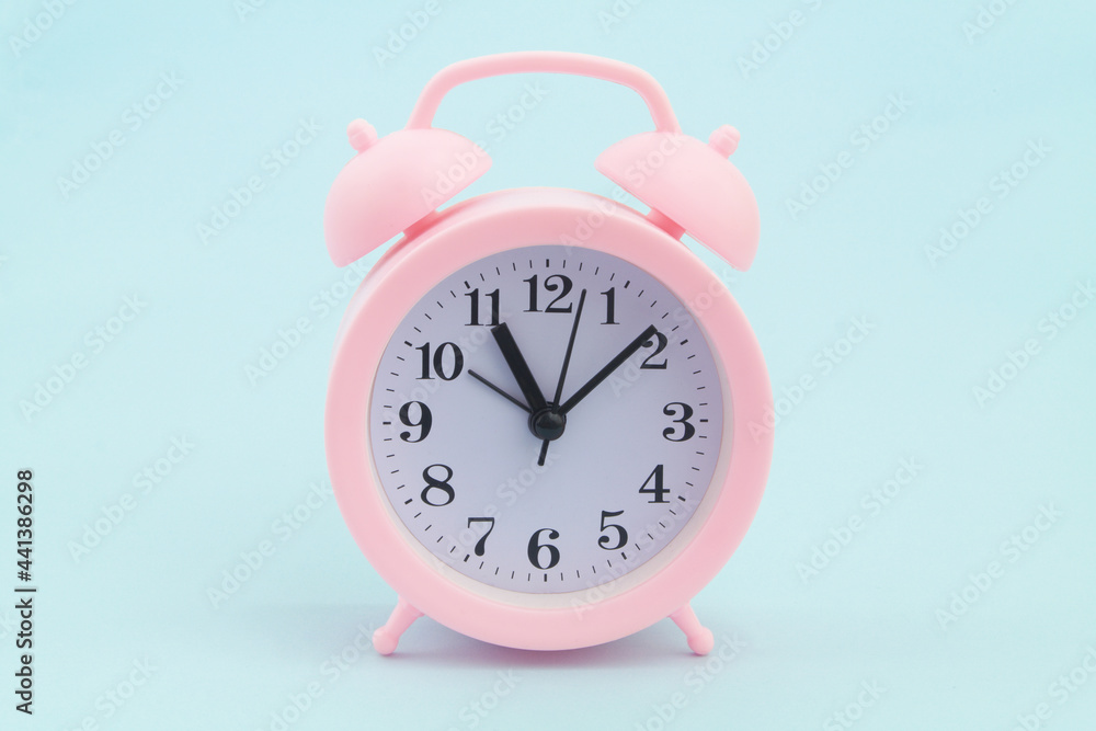 Pink alarm clock on blue background. Pink alarm clock on blue background.