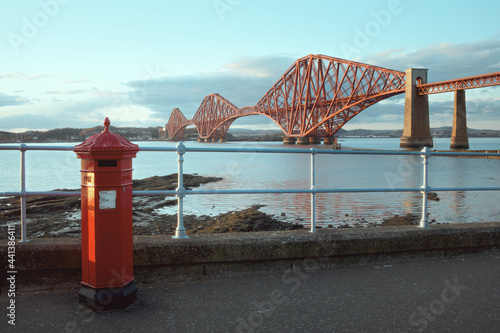 Obraz na plátně A red vintage British post box in front of the iconic Forth Rail Bridge in South