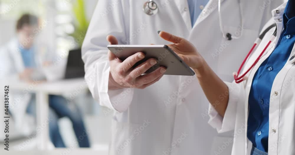 Cropped shot of medical team discussing over digital tablet at hospital Cropped shot of medical team discussing over digital tablet at hospital