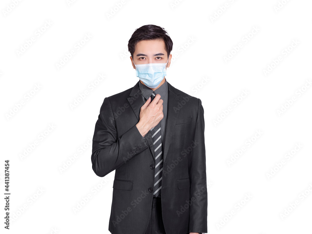 young businessman wearing medical mask during the COVID-19 pandemic, confidently adjusts his tie in front of the camera young businessman wearing medical mask during the COVID-19 pandemic, confidently adjusts his tie in front of the camera