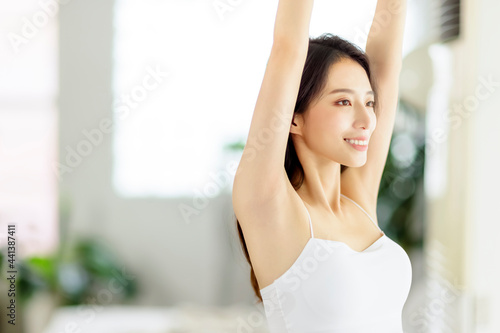 Young woman smiling and  taking a deep breath  in living room at morning