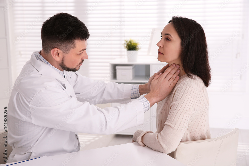 Doctor examining thyroid gland of patient in hospital Doctor examining thyroid gland of patient in hospital