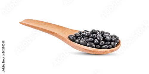 Black beans in wooden spoon on white background.