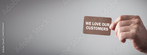 Canvas-taulu Male hand showing We Love Our Customers text.