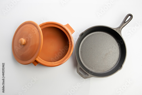 Top View of Cast Iron Skillet and Clay Pots Isolated on White Background