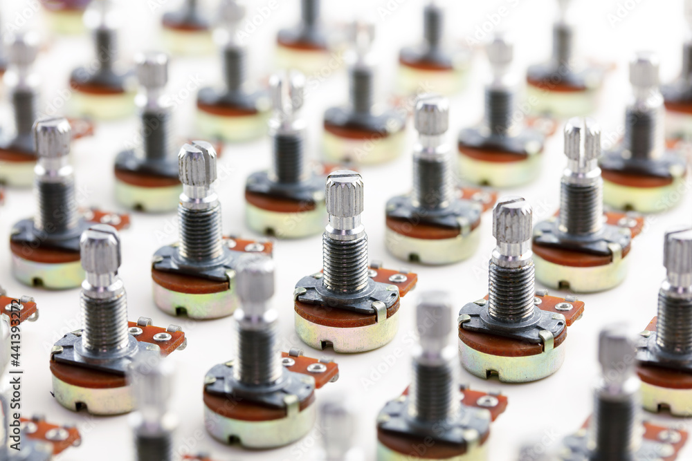 Electronic parts aligned. Many potention meters or variable resistors (also called volume pots) aligned on neutral white background. Electronic parts aligned. Many potention meters or variable resistors (also called volume pots) aligned on neutral white background.