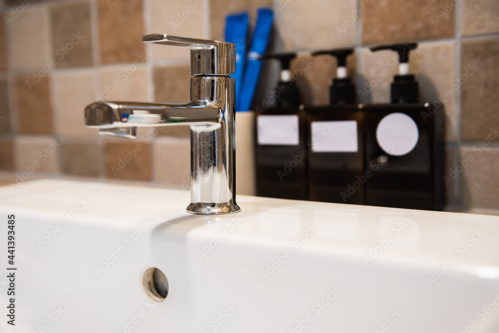 Chrome faucet washbasin. Interior of bathroom with sink basin faucet. Chrome faucet washbasin. Interior of bathroom with sink basin faucet.