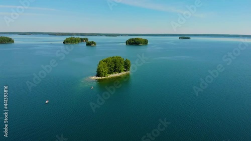 Aerial view of blue deep lake Uvildy, South Ural, Russia. Group of small green island on the lake against the backdrop of high mountains. Lush bright greenery and hot summer sun photo