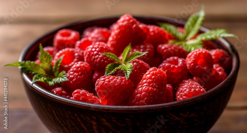 Delicious fresh juicy red raspberries on a dark table