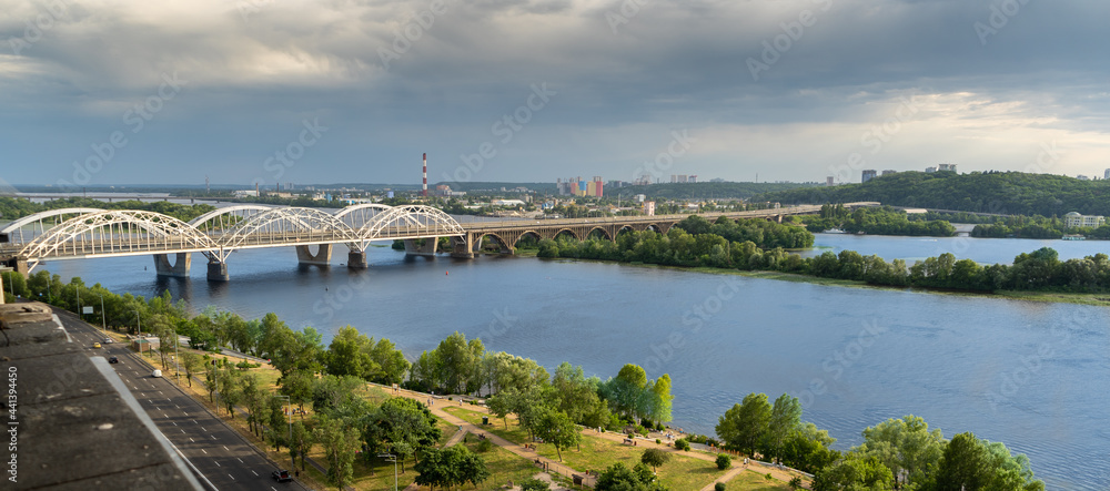 Panoramic view of the right bank of Kyiv. Dnieper river, evening and sunset. Metro bridge. Sight. Nice view from the balcony.