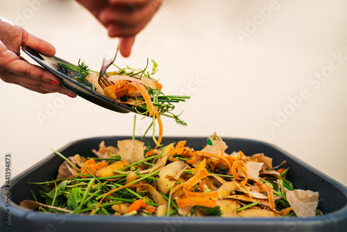 Tableau sur toile Une femme déverse ses pelures de légumes dans son composteur