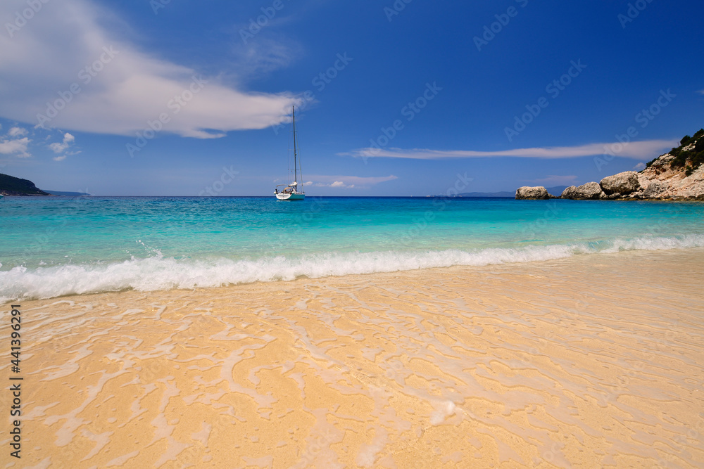 Sandy beach with rocky mountains and clear blue sea along the northern coast of the Greek island of Ithaca in the Ionian Sea
