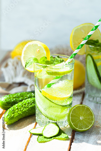 Refreshing cold summer drink: cucumber lemonade with lemon, lime and mint in a glass. Detox, light beverage with natural organic ingredients for hot weather. Close up macro copy space