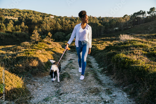 Woman with dog walking in nature photo