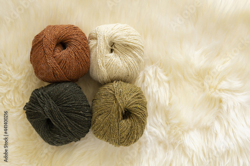 four tweed wool yarn skeins on white background