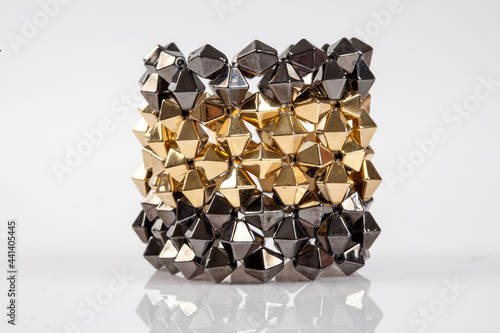 Golden and silver geometric structure used in fashion as a bracelet