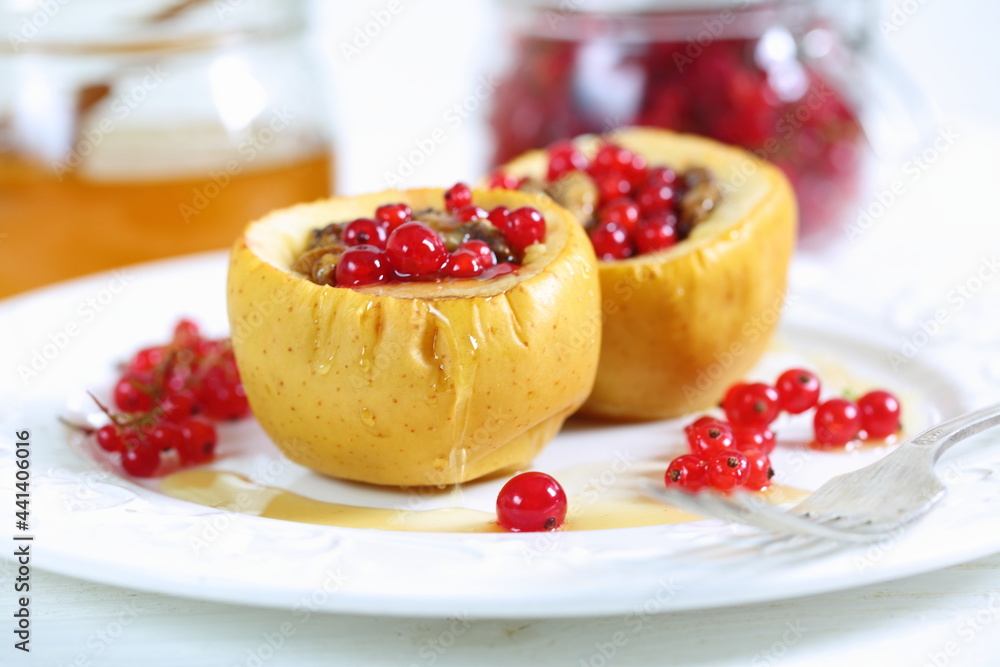 Baked apples with honey, walnuts, currants on a white background Baked apples with honey, walnuts, currants on a white background
