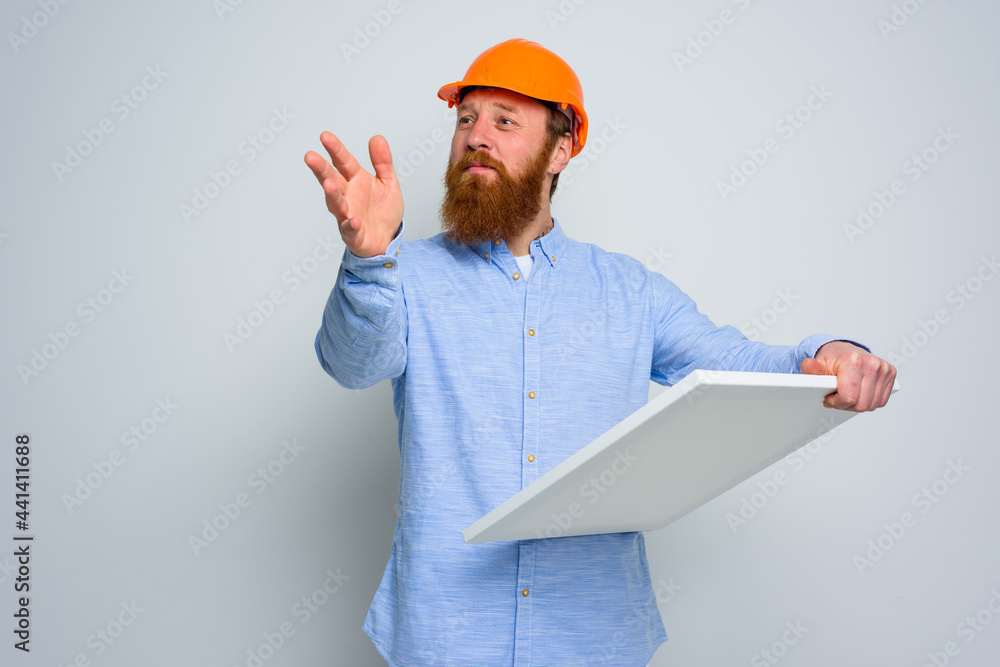 Confidant architect with beard and orange helmet does a sketch Confidant architect with beard and orange helmet does a sketch