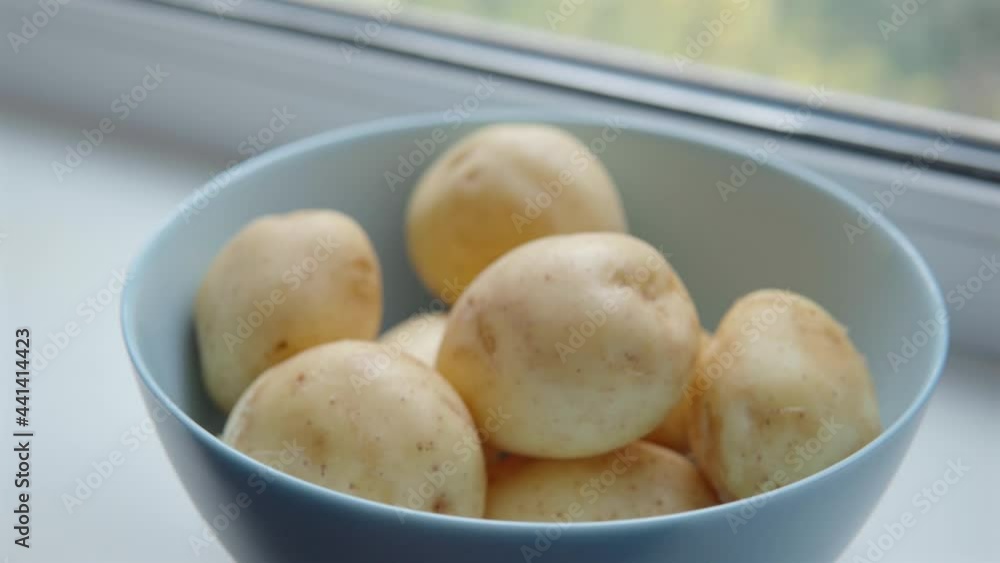 Close-up of the young ripe washed potatoes in a blue deep bowl. Close-up of the young ripe washed potatoes in a blue deep bowl.