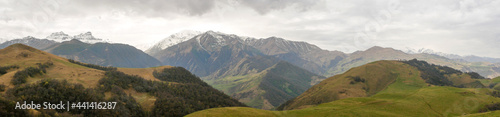 Aktoprak is a pass, known since ancient times, connecting the Baksan and Chegem gorges. Panorama view of green hills covered with vegetation and high mountains. Kabardino-Balkaria, Russia