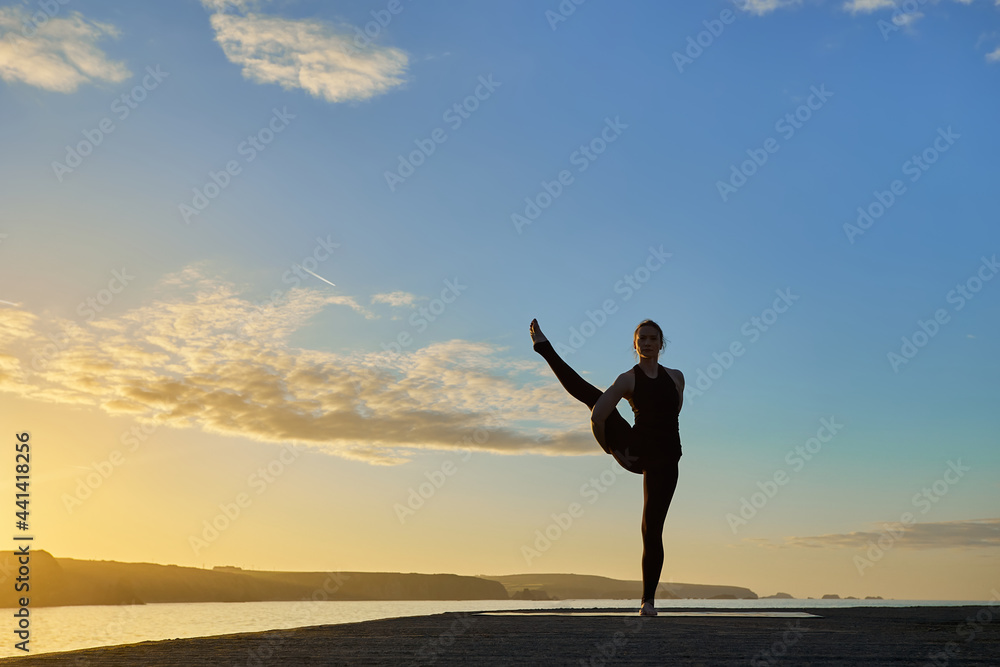 Advanced yoga posture in silhouette in a sunset