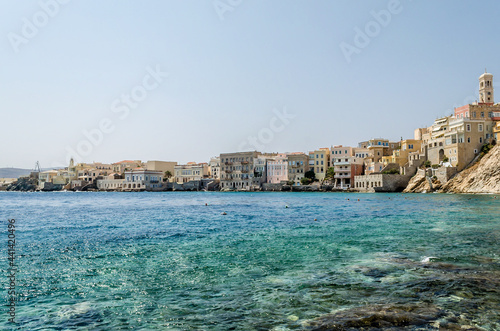 Fototapeta Naklejka Na Ścianę i Meble -  Famous Bay and Picturesque Neighborhood in Syros Island, Greece. Beautiful Scenic with Waterfront Buildings on a Sunny Day. Blue Sea and Sky