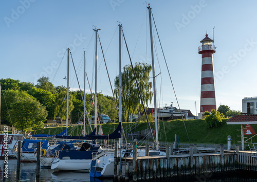 sailboats in the harbor of Kongsdal Huve on the Mariager Fjord with a lighthouse in the background photo