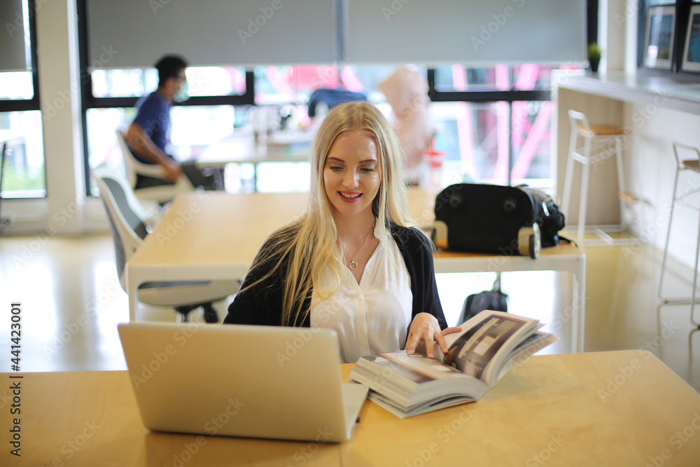 Obraz premium Female College Student Reading A Book In Library