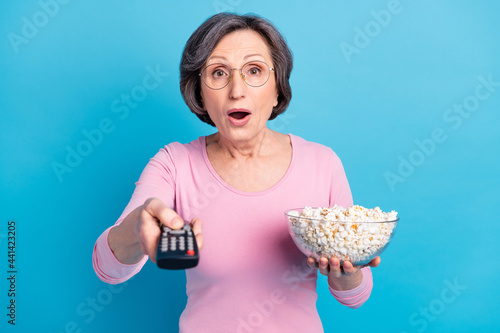 Photo of shocked surprised amazed mature woman watch tv eat popcorn head bad news isolated on blue color background