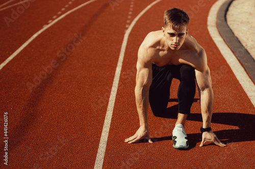 young guy with athletic body getting ready to run