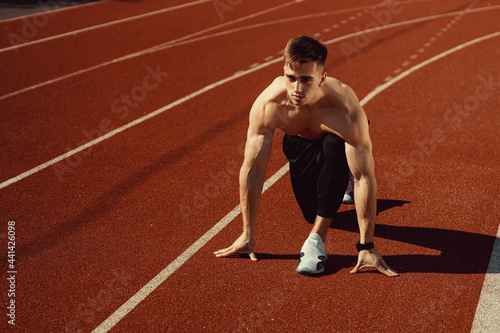 young guy with athletic body getting ready to run
