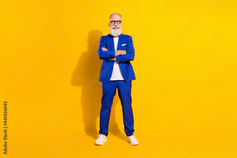 Full length body size view of nice chic classy cheerful man folded arms isolated over bright yellow color background Full length body size view of nice chic classy cheerful man folded arms isolated over bright yellow color background