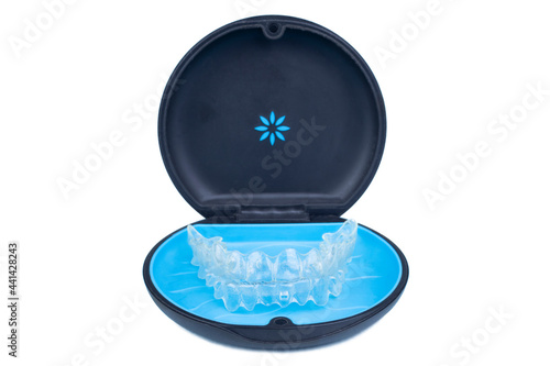 Isolated container with transparent aligner retainers or removable braces on white background