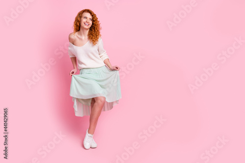 Full length body size photo of with red hair girl laughing wearing stylish spring clothes skirt isolated on pastel pink color background