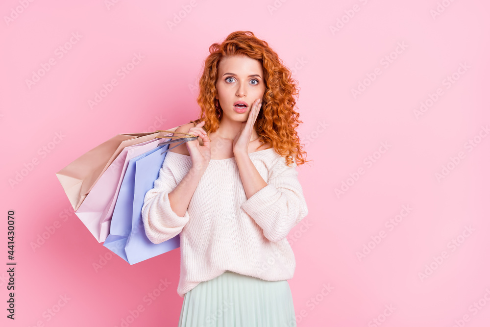 Photo of young girl amazed shocked surprised fake news hold bags shop isolated over pink color background Photo of young girl amazed shocked surprised fake news hold bags shop isolated over pink color background