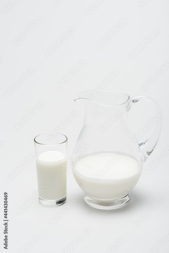 glass of milk and jug on white background glass of milk and jug on white background