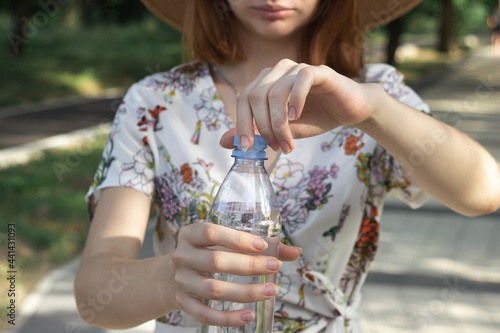 The girl opens a bottle of water. Pure drinking water in a plastic bottle. Opening bottle of water close-up
