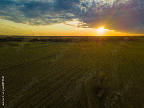 Beautiful countryside with green fields and meadows at sunset, drone view. Rural landscape at sunset