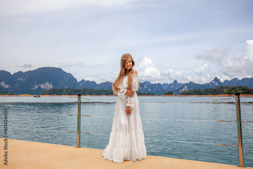 Happy Travel Girl Fun on Wooden Pier with Lake, Rainforest Jungle and Mountains on Background. Female Tourist Enjoy Vacation Cheow Lan Lake in Khao Sok National Park in Thailand Happy Travel Girl Fun on Wooden Pier with Lake, Rainforest Jungle and Mountains on Background. Female Tourist Enjoy Vacation Cheow Lan Lake in Khao Sok National Park in Thailand
