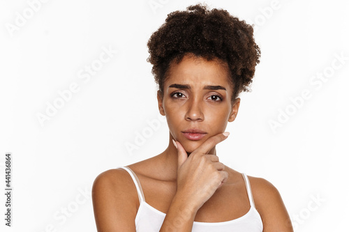 Young black woman in tank top frowning and looking at camera