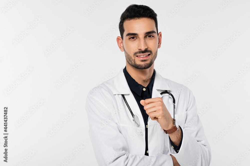 Positive arabian doctor in white coat looking a camera isolated on grey Positive arabian doctor in white coat looking a camera isolated on grey