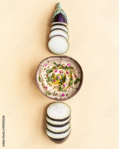 Bowl with Baba ghanoush dish on table with eggplants photo