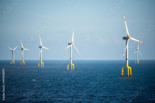 Offshore wind farm turbines at dusk in the middle of the sea photo