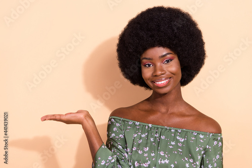 Photo of young attractive afro woman happy positive smile show hand product promo offer ad isolated over beige color background