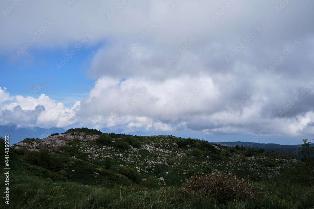 Forest and mountains in fog in cloudy weather. Cloud envelops rocky mountains and alpine meadows. Beautiful landscape of National Park of Russia. Forest and mountains in fog in cloudy weather. Cloud envelops rocky mountains and alpine meadows. Beautiful landscape of National Park of Russia.