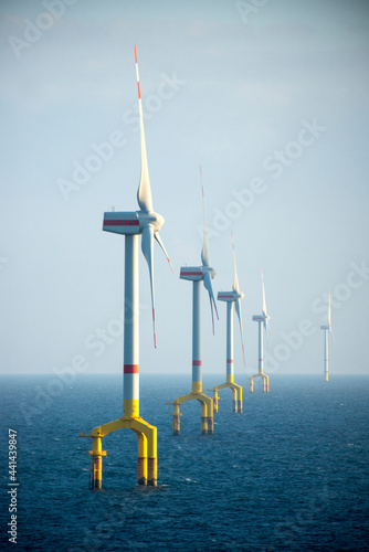 Offshore wind farm turbines at dusk in the middle of the sea