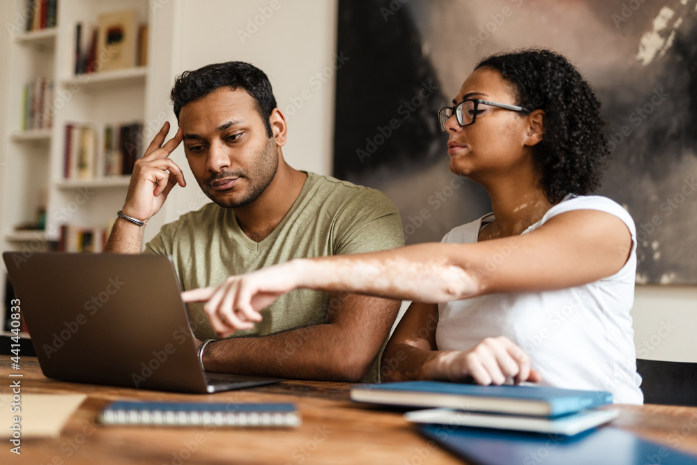 Middle eastern man and woman working with laptop together at home Middle eastern man and woman working with laptop together at home
